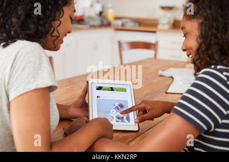 Two Teenage Girls Using Social Media On Digital Tablet Stock Photo