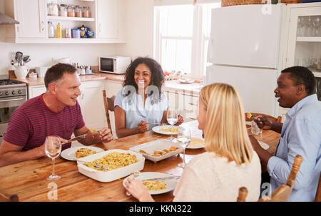 Mature Couple Entertaining Friends At Dinner Party Stock Photo