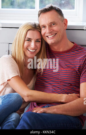 Portrait Of Romantic Couple Relaxing In Chair At Home Stock Photo