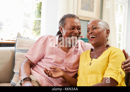 Smiling Senior Couple Sitting On Sofa At Home Together Stock Photo