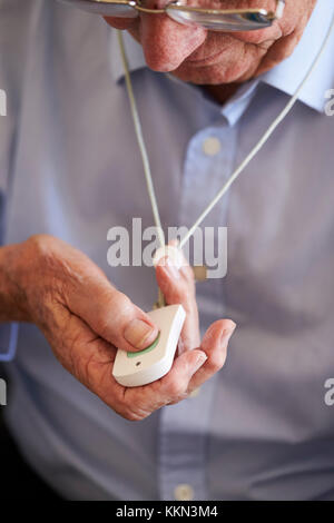 Senior Man At Home Using Distress Alarm Call Button Stock Photo