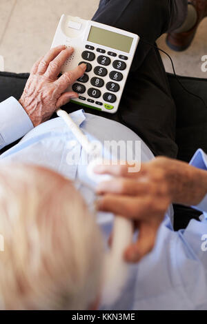 Senior Man At Home Using Telephone With Over Sized Keys Stock Photo