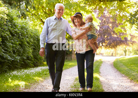 Grandparents On Walk In Countryside With Baby Grandson Stock Photo
