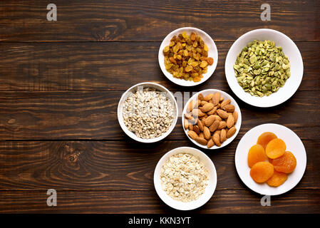 Bowl with ingredients for cooking granola on wooden background with copy space. Top view, flat lay Stock Photo