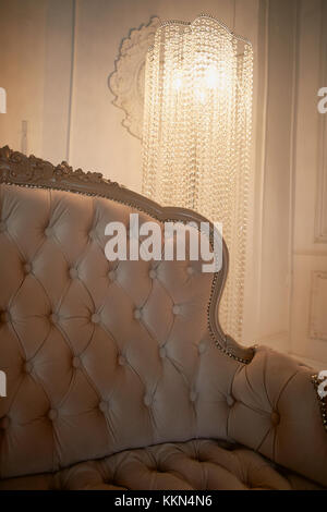 The upholstery of the sofa beige color.Retro. Classic style and crystal floor lamp Stock Photo
