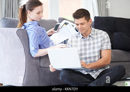 Freelance Couple Working From Home Looking At Laptop Together Stock Photo