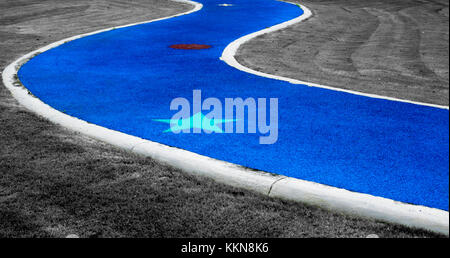 Blue abstract road with green star paint and gray grass as background Stock Photo