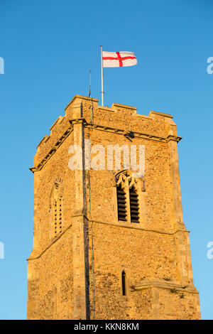 Saint George red and white flag flying against blue sky from church tower, Shottisham, Suffolk, England, UK Stock Photo