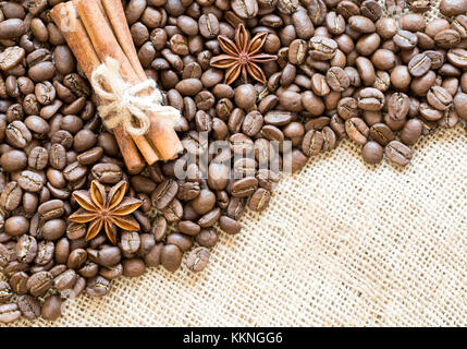 Coffee beans with anise and cinnamon on burlap close-up. Place for text. Stock Photo