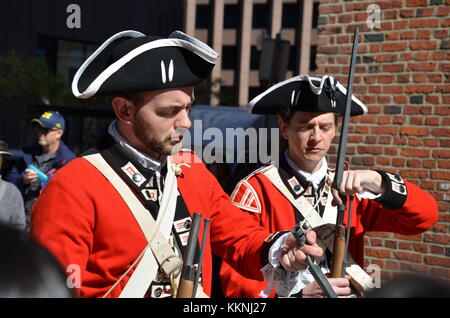 Soldiers dressed in British Army Uniform reinact a key ceremony for tourists in front of The Old State House Boston Massachusetts Stock Photo
