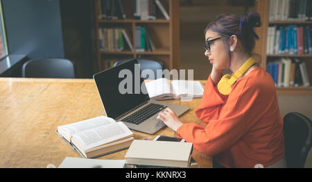 Girl using laptop at desk Stock Photo