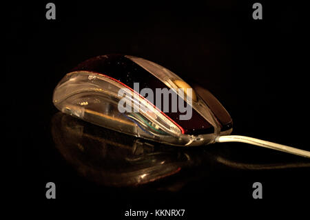 Old PC mouse (pointing device) resting on a table, on a black background Stock Photo