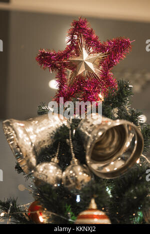 Christmas Silver bell and star hanging on a beautiful Christmas tree surrounded by red and white shinning ball Stock Photo