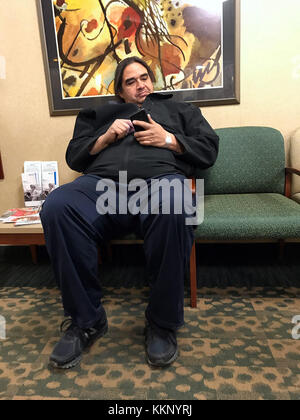 Man in waiting room with cell phone, Stock Photo