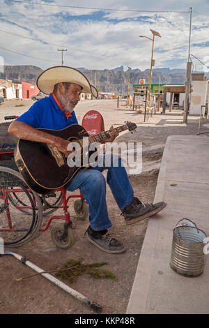 Boquillas del Carmen, Coahuila, Mexico - A man in a wheelchair plays a guitar, hoping for tips from tourists. The small border town of Boquillas is po Stock Photo