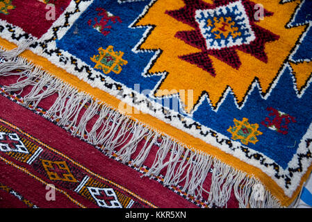 Colourful hand woven berber carpets spread on the bazaar floor in Morocco Stock Photo
