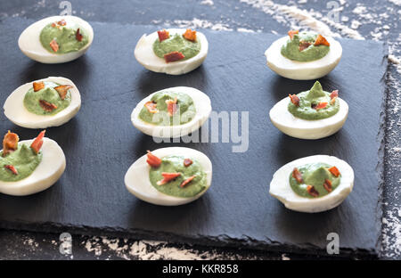 Spinach and bacon deviled eggs Stock Photo