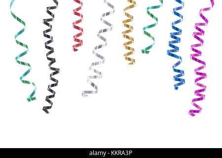 horizontal festive image with close-up multi coloured rolls curly ribons hanging from the top on black backgroung Stock Photo