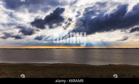 The sun shines through the clouds near Agger Tange Stock Photo