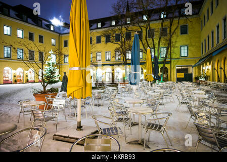 Germany, Bavaria, Munich, Funf Hofe luxury shopping center, outdoor cafe under snow, evening Stock Photo
