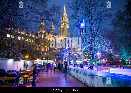 Austria, Vienna, Rathausplatz ice skating rink by Town Hall, Christmastime, evening Stock Photo