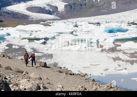 Tourists walking along Fjallsarlon Iceberg Lagoon, austurland, eastern Iceland, iceland Stock Photo