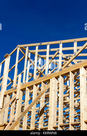 Wood construction frame of housing development detached house construction site using lumber 2X4 stud construction material. Stock Photo