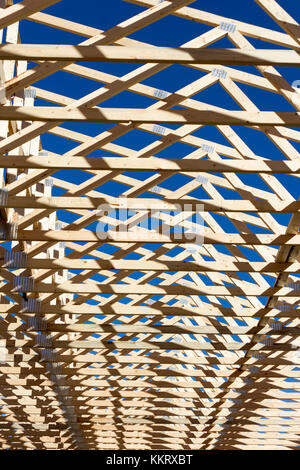 Wood construction frame of housing development detached house construction site using lumber 2X4 stud construction material. Stock Photo