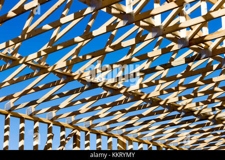 Wood construction frame of housing development detached house construction site using lumber 2X4 stud construction material. Stock Photo