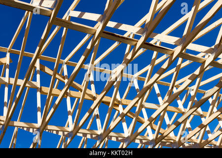 Wood construction frame of housing development detached house construction site using lumber 2X4 stud construction material. Stock Photo