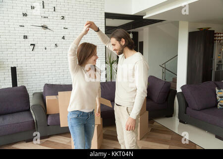 Happy young couple dancing in new home on moving day Stock Photo