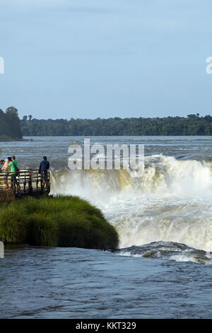 Tourists on lookout by Devil's Throat (Garganta del Diablo), Iguazu Falls, on Argentina - Brazil Border, South America Stock Photo