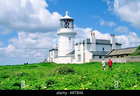 Coast path passes lighthouse on Caldey Island off the Pembrokeshire coast of south Wales near Tenby Stock Photo