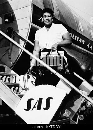 Ella Fitzgerald, the famous jazz singer, is captured disembarking from a Convair 440 Metropolitan aircraft. This image highlights her significant role in 20th-century music and her travel as an international performer. Stock Photo