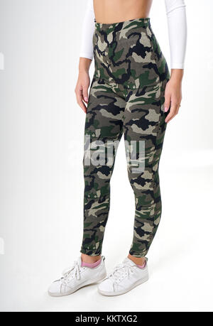 Girl in camouflage leggings, white blouse and white sneakers Stock Photo -  Alamy