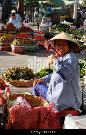 Beautiful  fruits market at Cho Lon, Vietnam in early morning, colorful fruit basket show at open air market, friendly saleswoman with smiling face Stock Photo