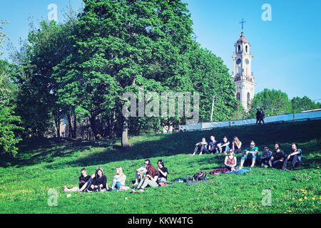 Vilnius, Lithuania - May 19, 2017: Young people sitting on the green grass, in Vilnius, Lithuania. Stock Photo