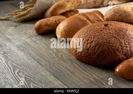 Fresh bread on wooden worktop Stock Photo