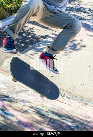 a guy running a kickflip skateboarding. Stock Photo