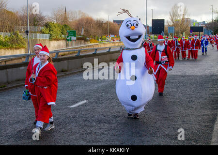 Liverpool, Merseyside, UK  3th December, 2017. The BTR Liverpool Santa Dash centre starts with a 5K road route beginning at the Pier Head on Canada Boulevard in front of the Liver Buildings. The festive spectacle with thousands of Santas mascots running for fun around the streets event is open to runners, joggers and walkers but everyone has to take part in the Santa suit provided either red for Liverpool FC  or blue for Everton FC.  It finishes in front of the Town Hall at Castle Street. Credit: MediaWorldImages /Alamy Live News Stock Photo