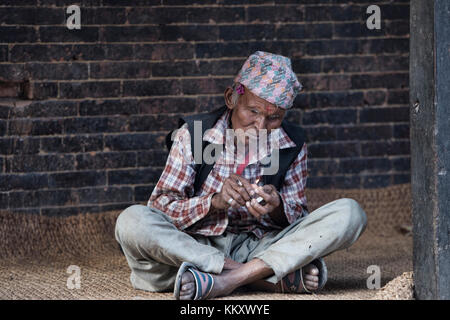 Old man lights his cigarette, Kathmandu, Nepal Stock Photo