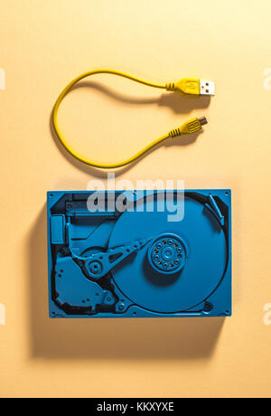 Blue colour hard disc and yellow USB cable Stock Photo