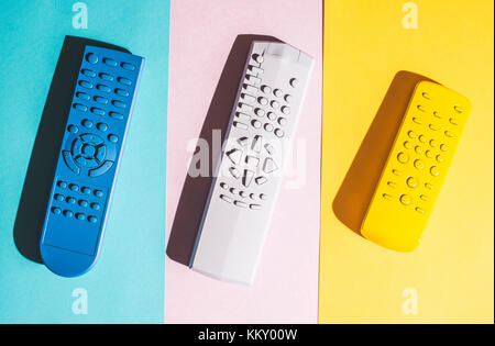 Many Colored TV remote controls on bright backgrounds. Stock Photo