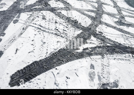 Car tire tracks pattern on dirty wet snow, background texture Stock Photo