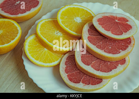 On a plate of sliced orange and grapefruit. Presents closeup. Stock Photo