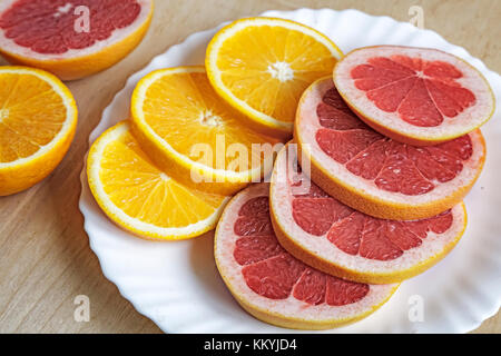 On a plate of sliced orange and grapefruit. Presents closeup. Stock Photo