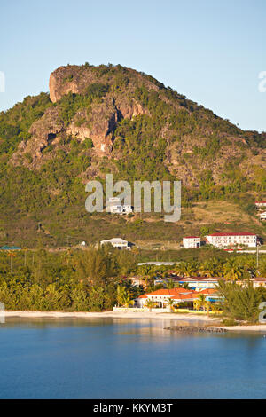 A small beach with buildings in the Antiguan landscape near Jolly Harbour. Stock Photo