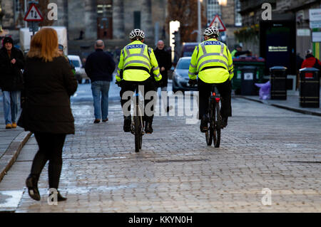 Two Police Scotland cyclists on patrol riding their bicycles along Reform Street in Dundee, UK Stock Photo