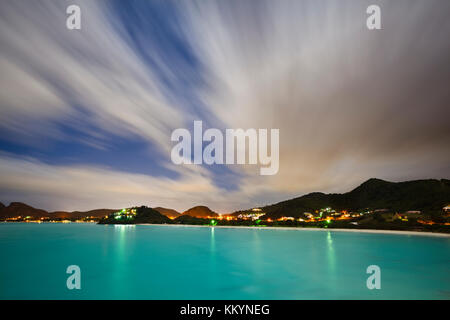 Night shot of a caribbean beach in Antigua, the full moon illuminating the turquoise water. Stock Photo