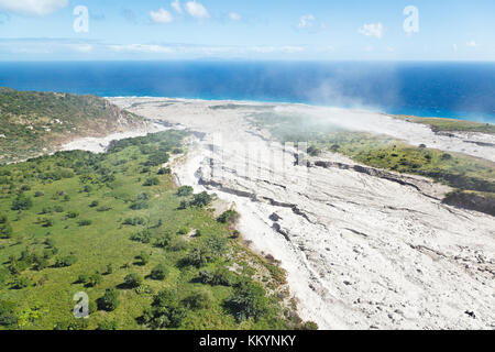 The dusty and steaming remains of recent pyroclastic flows of the Soufriere Hills Volcano in Montserrat. Aerial view from helicopter. Stock Photo